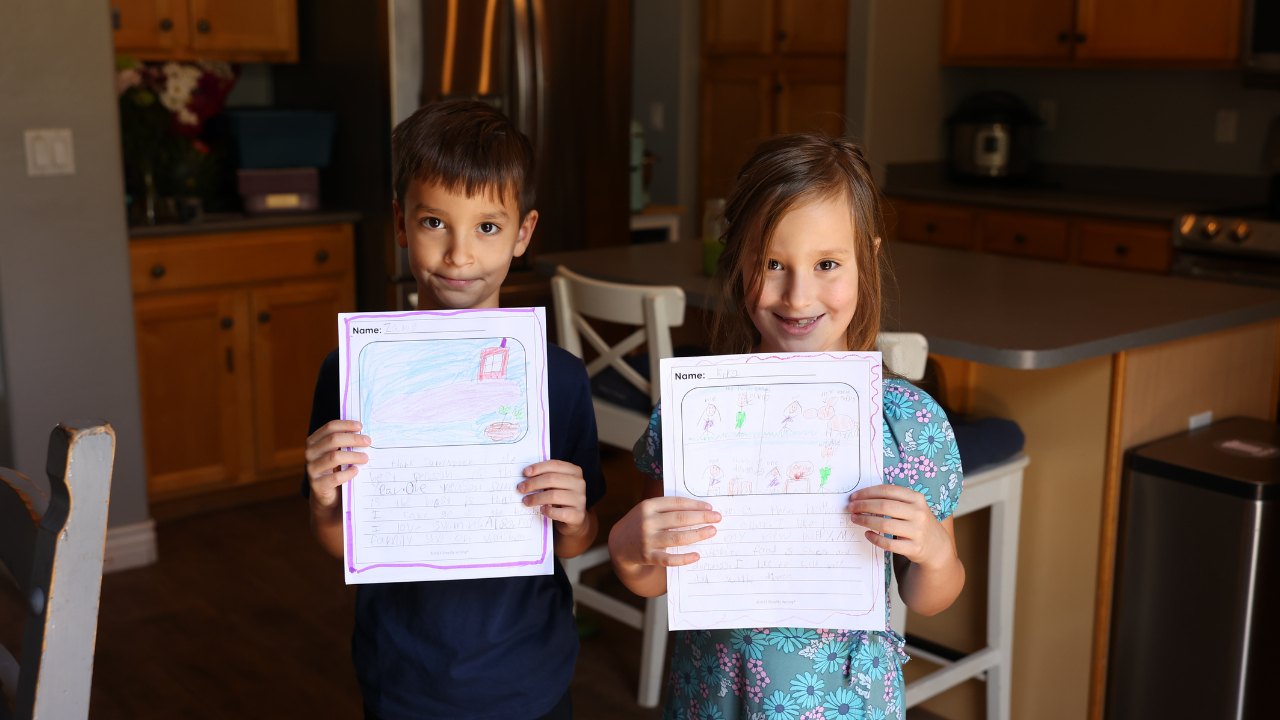 Two children holding their waiting pieces with artwork.